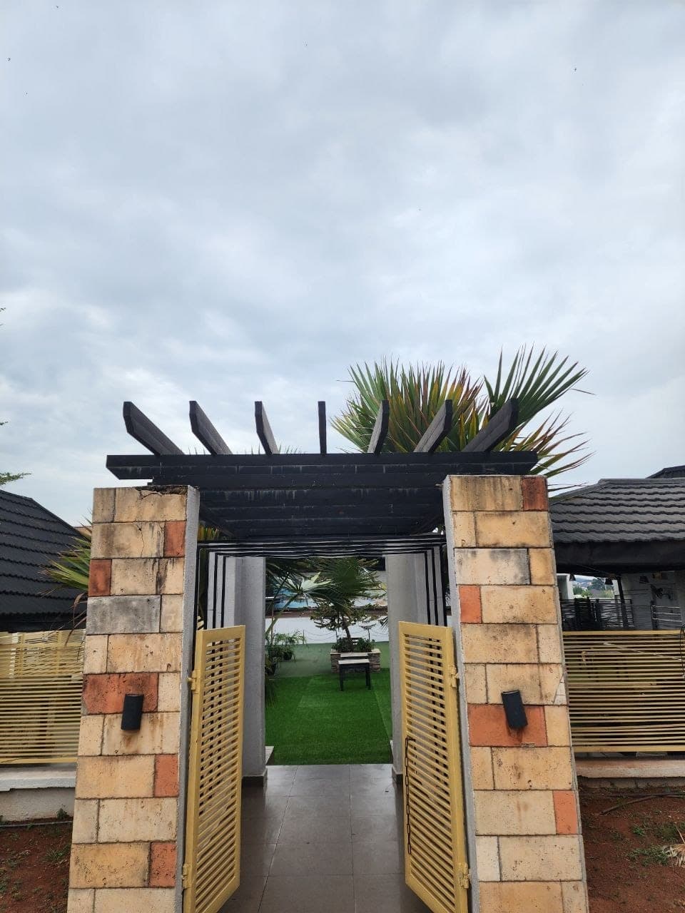 The park gate open onto the lawn by day
